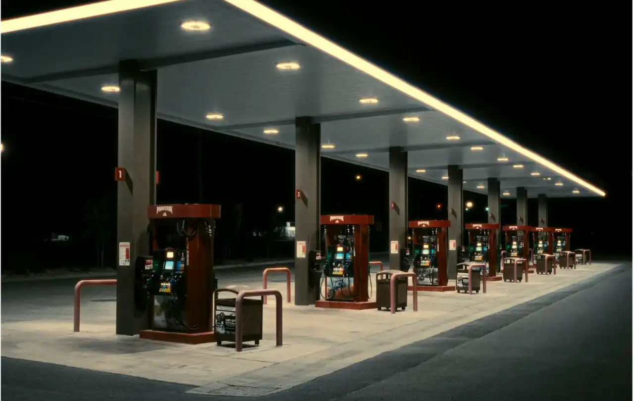Commercial gas station fuel dispensers at night representing petroleum environments where shielded FEP control cables support dispenser communication and control systems