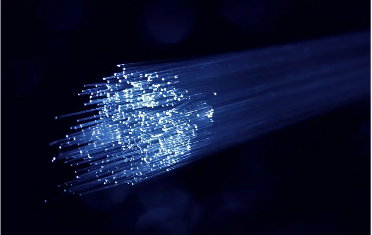 Close-up of illuminated fiber optic strands representing premade fiber optic cable used in enterprise network infrastructure and data transmission