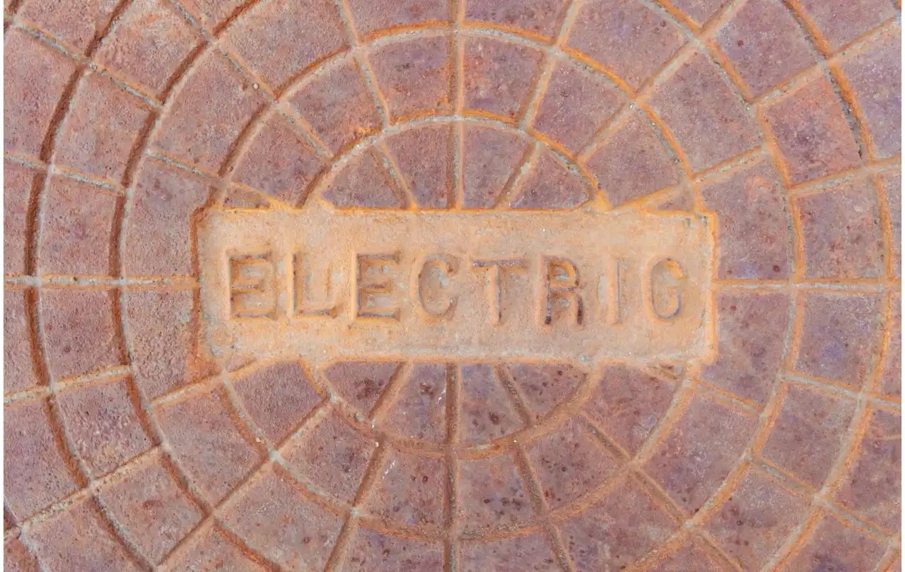 Underground electrical access cover representing CATV and outdoor cable infrastructure in commercial utility pathways
