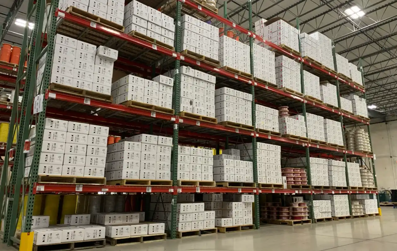 Organized warehouse racks of low‑voltage cable boxes and reels ready for shipment at Windy City Wire.