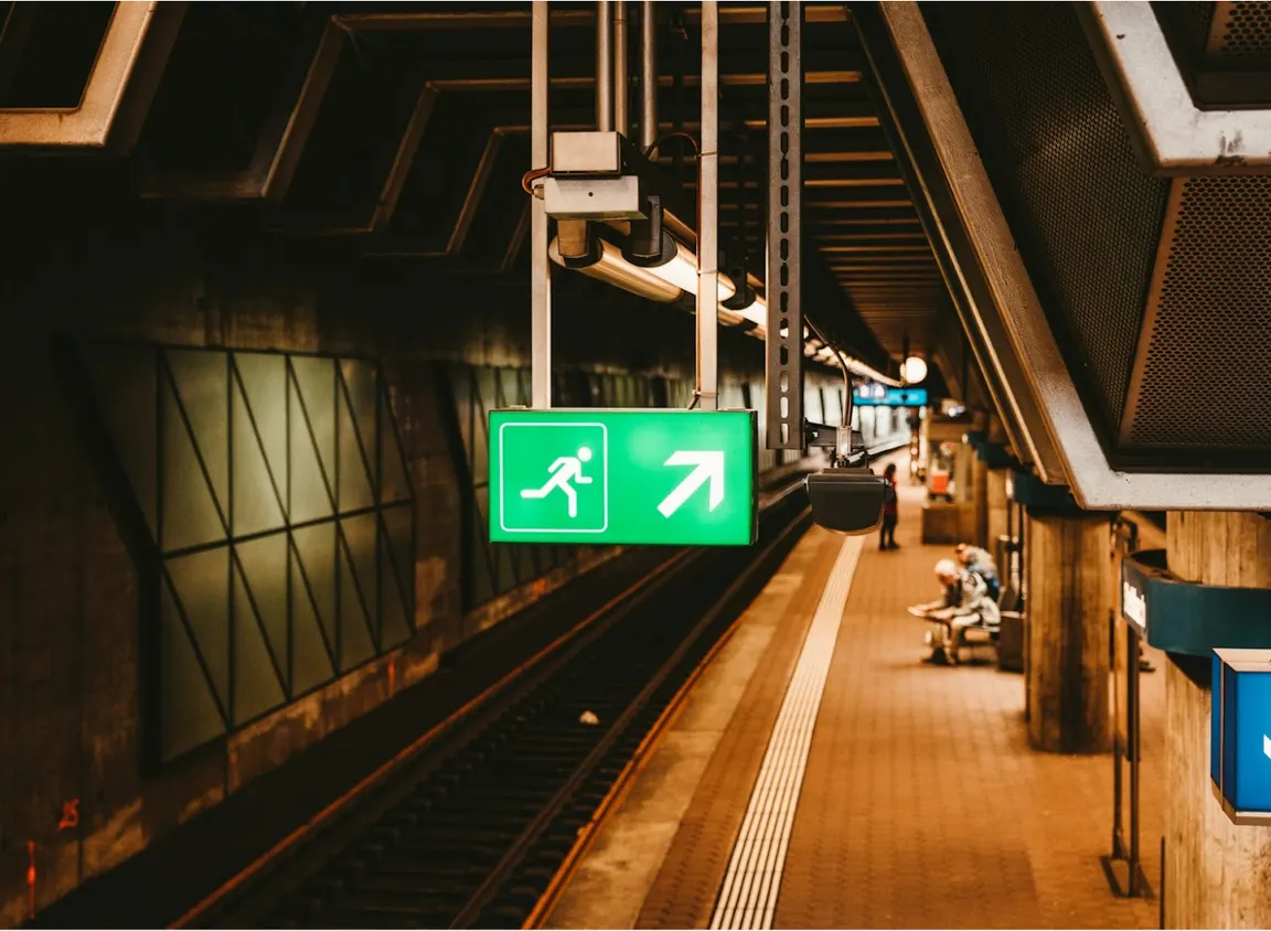 Emergency exit sign in a commercial transit station, representing life-safety systems supported by fire alarm cable and reliable low-voltage system performance