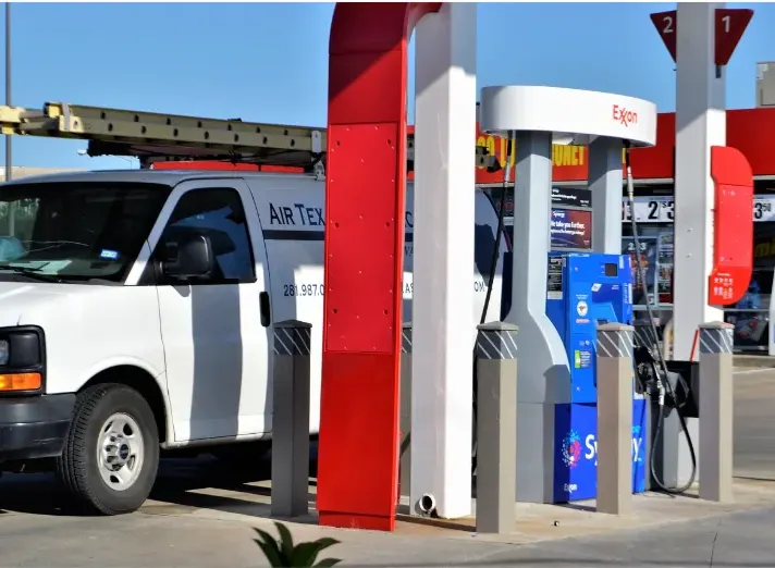 Service technician vehicle at a commercial gas station where petroleum-rated cable supports underground storage tank monitoring, CRIND systems, and secure EMV fuel transactions