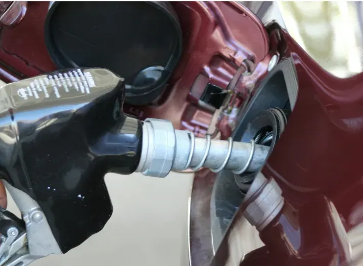 Fuel dispenser filling a vehicle at a gas station, representing the petroleum infrastructure supported by underground storage tank (UST) wire and cable systems