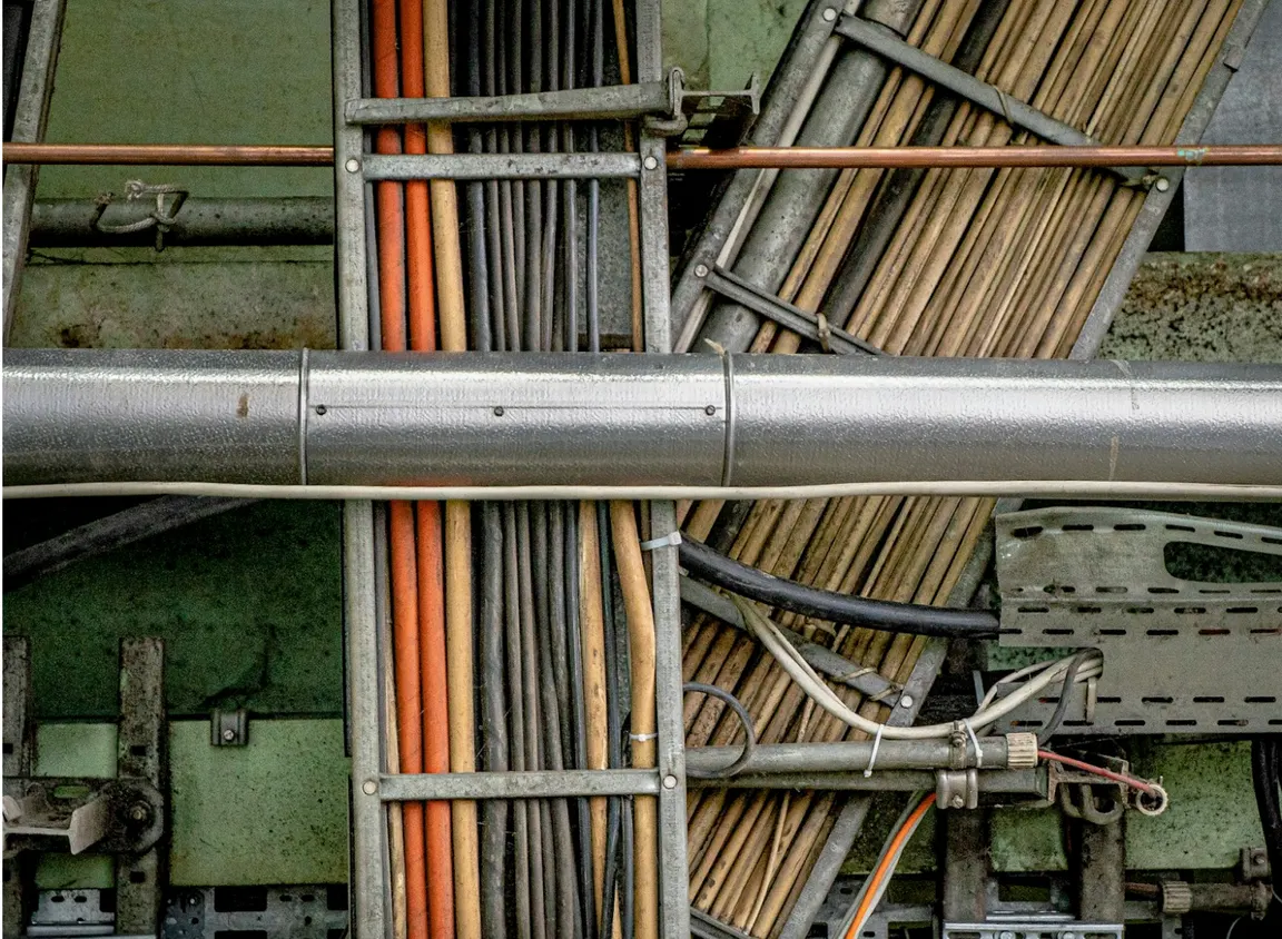 Cable tray with multiple colored Ethernet and power cables in a commercial installation showing organized cable routing and jacket color identification for outdoor Cat6 and structured cabling systems