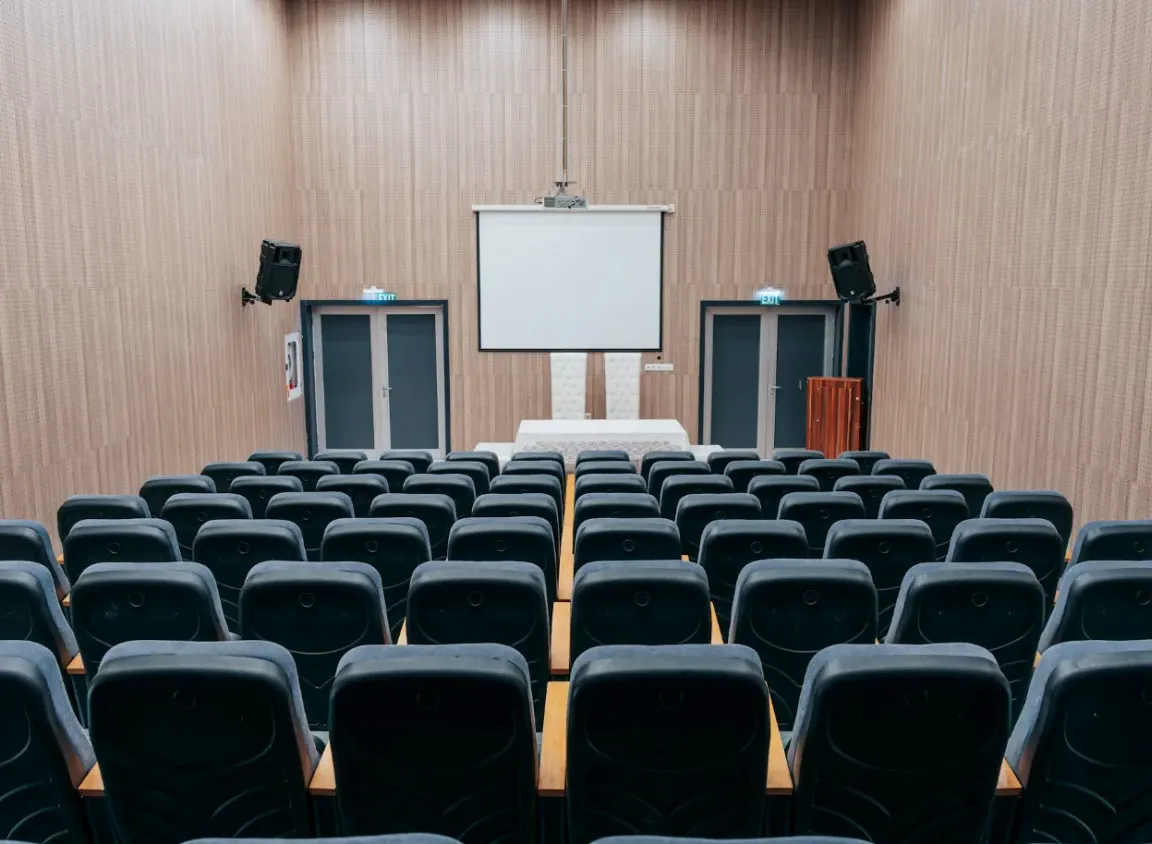Commercial auditorium with a projector, display screen, and AV equipment illustrating a typical environment where RS-232 and RS485 digital media cable supports reliable AV control systems.